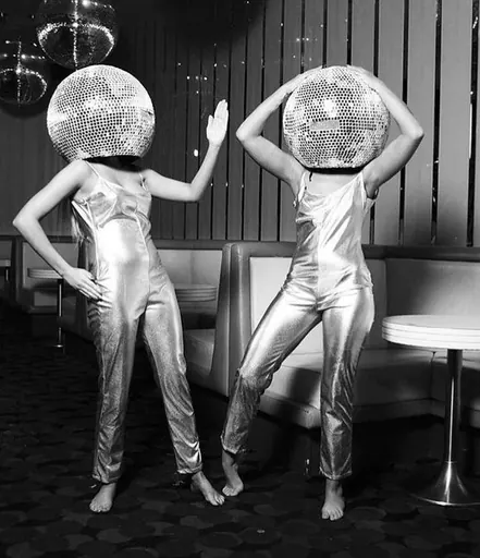 Two performers in silver jumpsuits with mirrorball heads